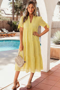 Woman in a yellow dress standing by a poolside